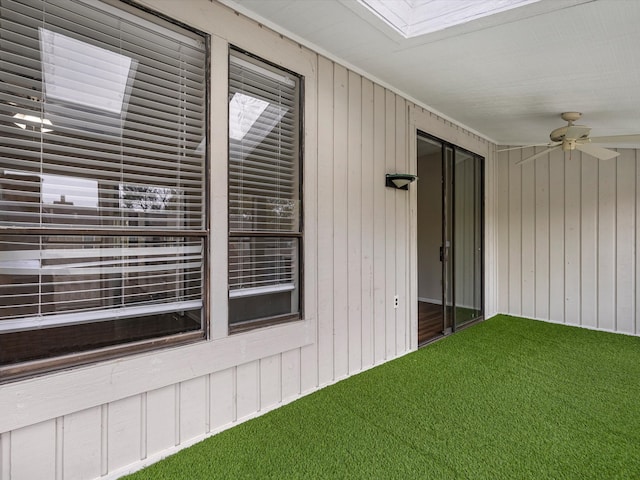 unfurnished sunroom with a skylight and ceiling fan