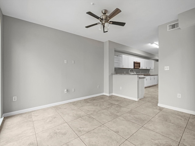 unfurnished living room featuring light tile patterned flooring, visible vents, baseboards, and ceiling fan