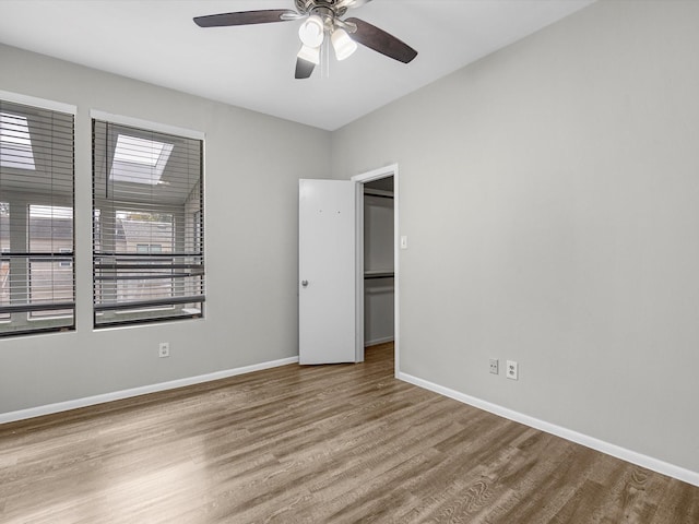 unfurnished bedroom featuring baseboards, wood finished floors, and a ceiling fan