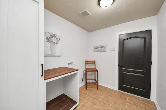 clothes washing area with hookup for a washing machine, light tile patterned floors, baseboards, visible vents, and laundry area