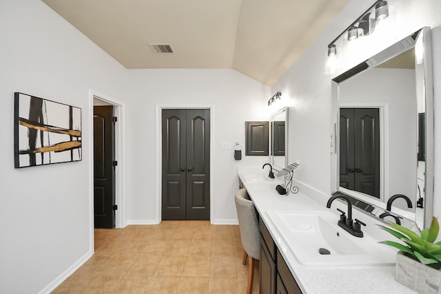 full bathroom featuring vaulted ceiling, visible vents, double vanity, and a sink