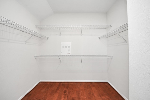 spacious closet with lofted ceiling and wood finished floors