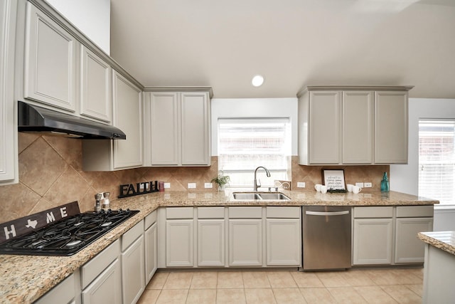 kitchen featuring under cabinet range hood, dishwasher, decorative backsplash, black gas stovetop, and a sink