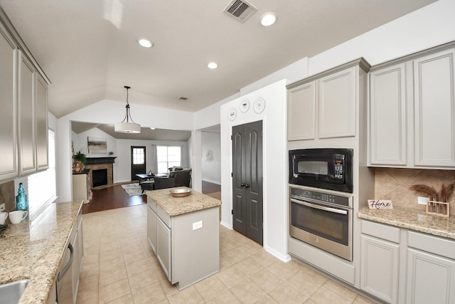 kitchen with visible vents, gray cabinetry, black microwave, and stainless steel oven