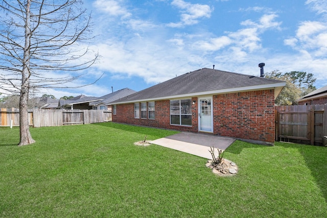 back of house featuring brick siding, a shingled roof, a lawn, a fenced backyard, and a patio area