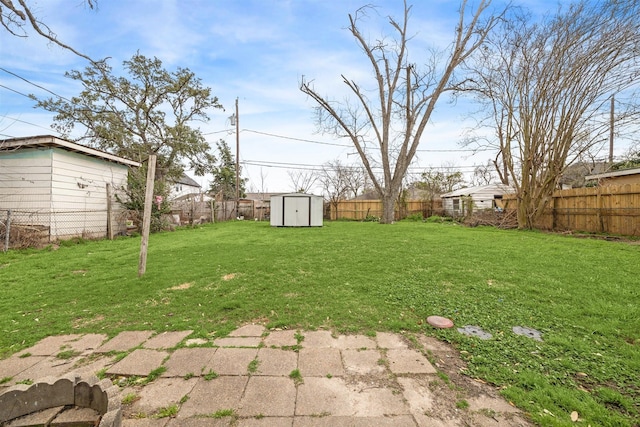 view of yard with a storage unit, a fenced backyard, and an outdoor structure