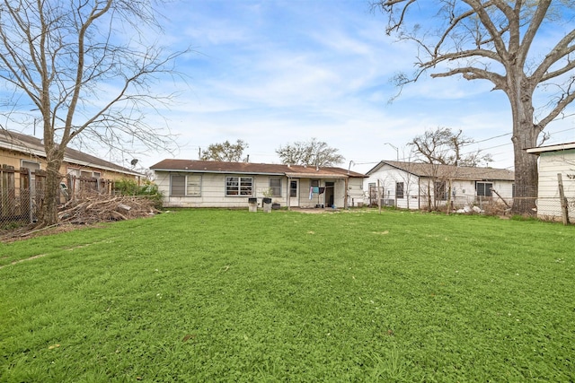 rear view of property with a yard and fence