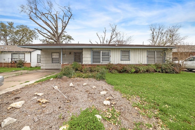 ranch-style house with an attached carport, board and batten siding, and a front lawn