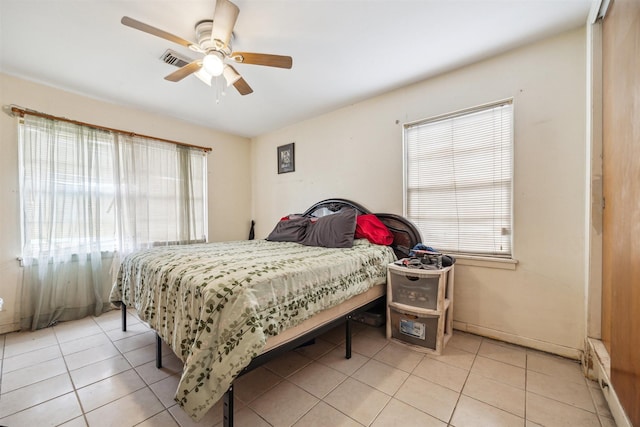 bedroom featuring light tile patterned floors, visible vents, baseboards, and a ceiling fan