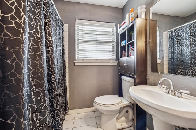 full bathroom with curtained shower, tile patterned floors, toilet, and a sink