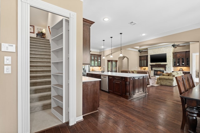 kitchen with visible vents, a ceiling fan, stainless steel dishwasher, a stone fireplace, and light countertops