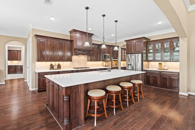 kitchen with a sink, stainless steel appliances, arched walkways, and light countertops