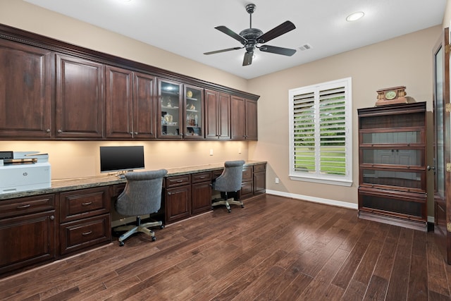 office area featuring visible vents, built in desk, baseboards, ceiling fan, and dark wood-style flooring