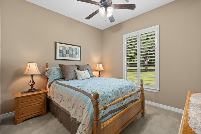 bedroom featuring baseboards, light colored carpet, and ceiling fan