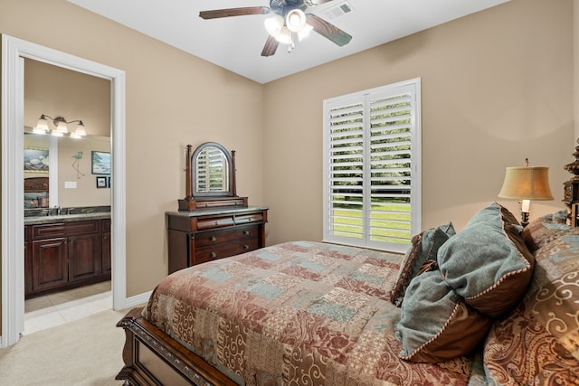 bedroom featuring visible vents, a ceiling fan, connected bathroom, baseboards, and light colored carpet