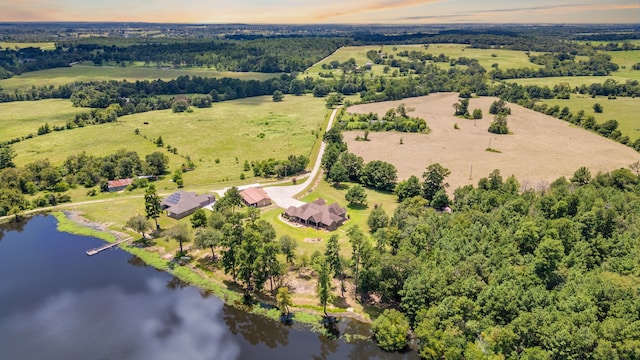 aerial view at dusk featuring a water view and a rural view