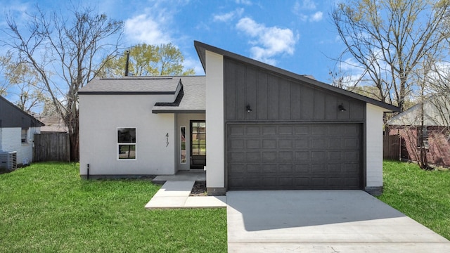 view of front facade featuring a front yard, fence, driveway, roof with shingles, and an attached garage