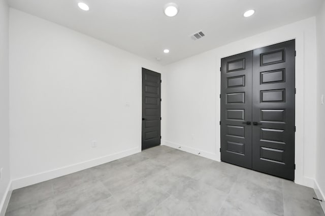 spare room featuring recessed lighting, visible vents, and baseboards