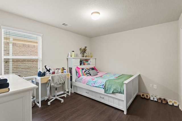 bedroom with visible vents, a textured ceiling, and dark wood-style flooring