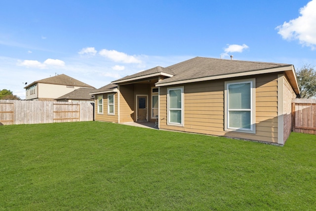 back of house with a lawn and a fenced backyard