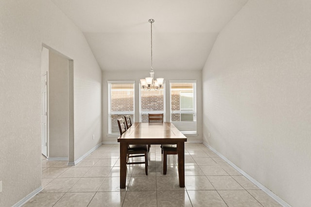 dining room featuring light tile patterned floors, baseboards, lofted ceiling, and a notable chandelier