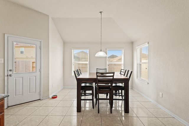 dining area featuring lofted ceiling, light tile patterned floors, and baseboards