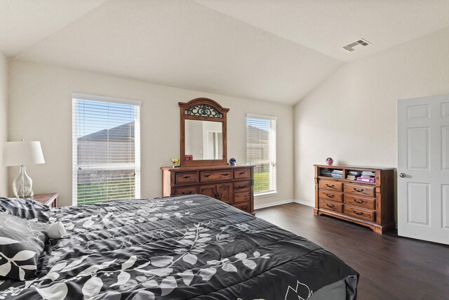 bedroom featuring visible vents, lofted ceiling, and dark wood-style floors