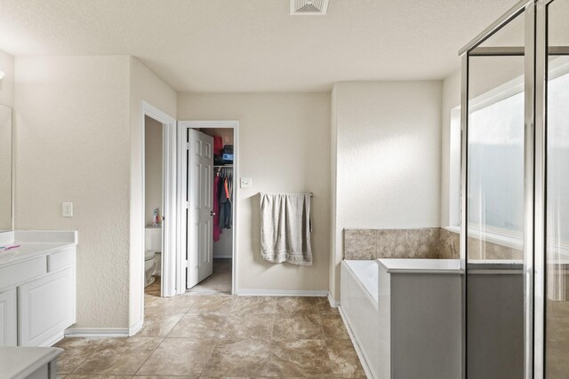 full bathroom featuring vanity, a bath, visible vents, a stall shower, and toilet