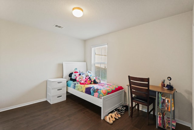 bedroom featuring visible vents, baseboards, and dark wood-type flooring