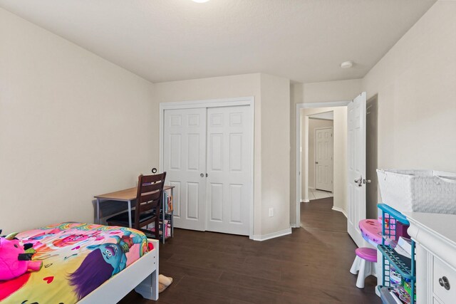 bedroom featuring wood finished floors, a closet, and baseboards