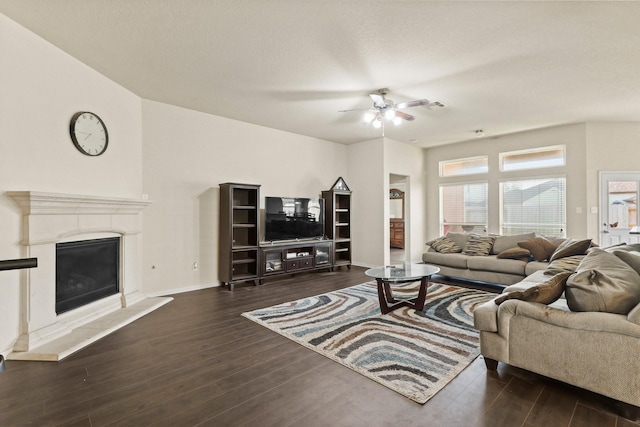 living room with visible vents, a glass covered fireplace, wood finished floors, baseboards, and ceiling fan