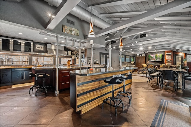 bar featuring beam ceiling, high vaulted ceiling, visible vents, and a sink