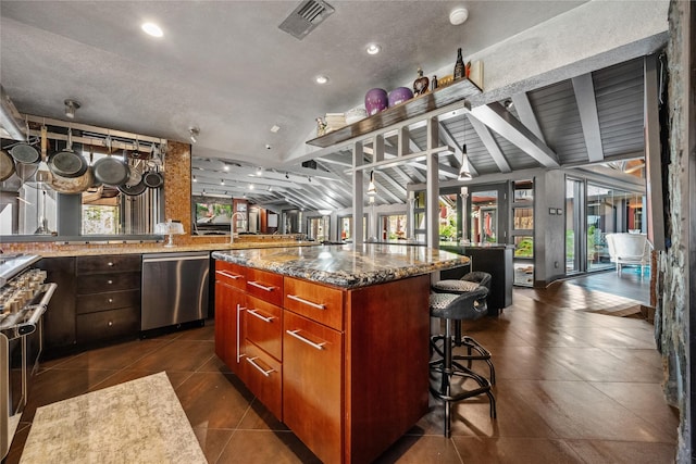 kitchen with lofted ceiling with beams, a kitchen island, dark stone counters, a breakfast bar area, and dishwasher