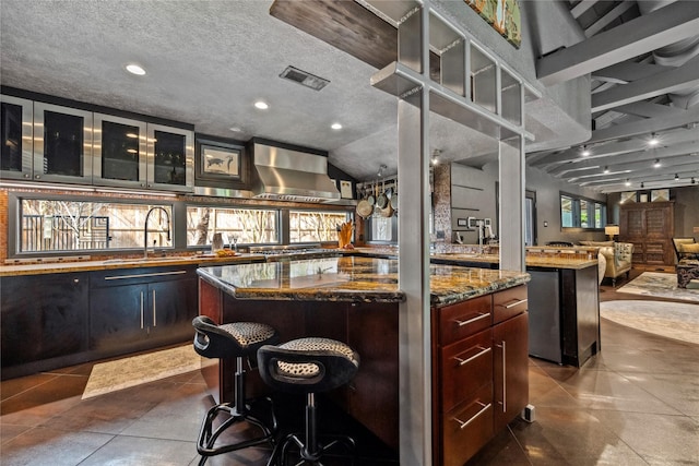 bar featuring visible vents, dark tile patterned floors, recessed lighting, a textured ceiling, and wall chimney exhaust hood