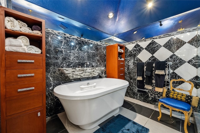 full bathroom featuring a freestanding tub, tile walls, and tile patterned flooring