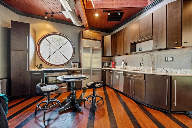 kitchen with a sink, dark brown cabinets, appliances with stainless steel finishes, wooden ceiling, and dark wood-style flooring