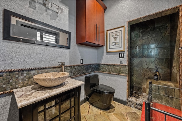 kitchen with stone finish flooring, a textured wall, and a sink