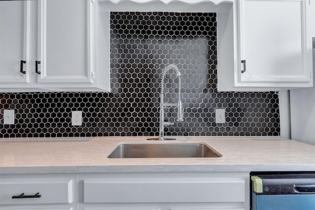 kitchen featuring backsplash, white cabinets, dishwasher, and light countertops