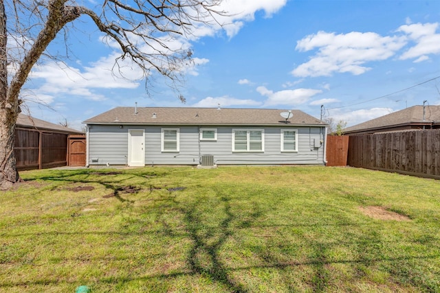 rear view of property with central AC unit, a fenced backyard, and a lawn