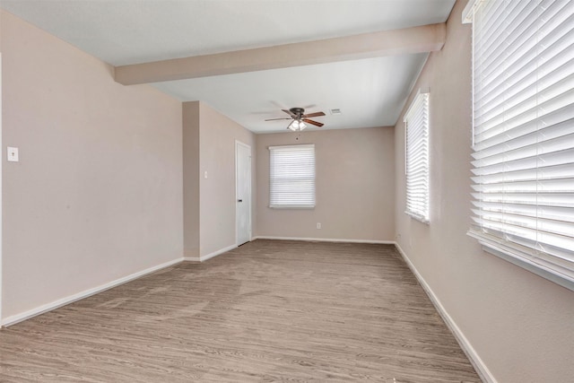 spare room with light wood-type flooring, baseboards, beam ceiling, and a ceiling fan