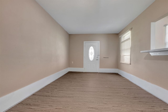 foyer featuring baseboards and wood finished floors