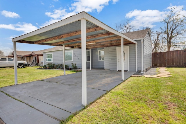 exterior space featuring an attached carport, fence, and driveway