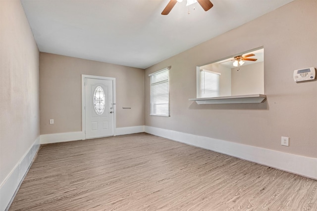 foyer entrance with baseboards, wood finished floors, and a ceiling fan