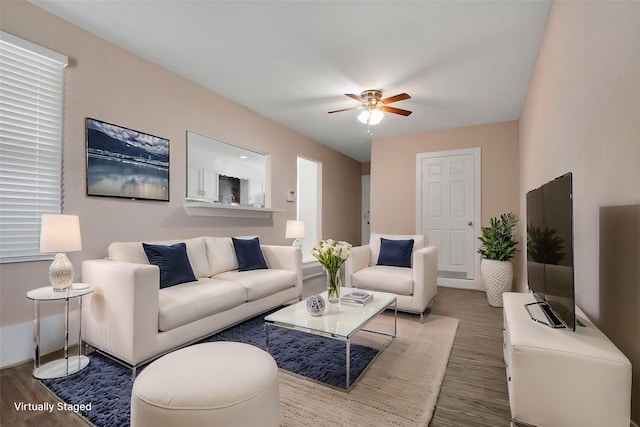 living room with wood finished floors and ceiling fan