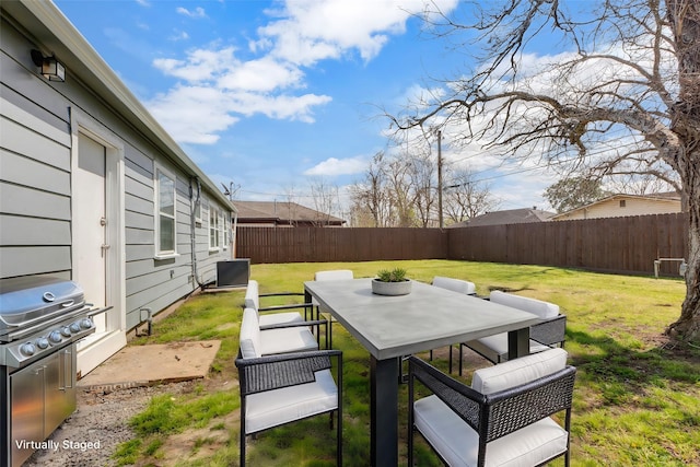 view of yard with outdoor dining area and a fenced backyard