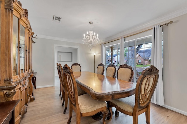 dining room featuring visible vents, an inviting chandelier, light wood-style flooring, and crown molding