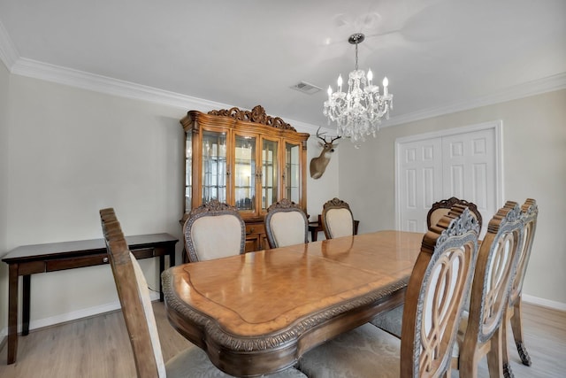 dining room with light wood-style floors, visible vents, a notable chandelier, and ornamental molding