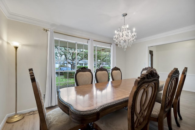 dining space with light wood-type flooring, baseboards, a notable chandelier, and crown molding