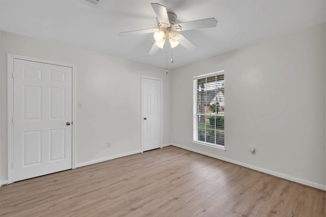 empty room with baseboards, light wood-style flooring, and a ceiling fan