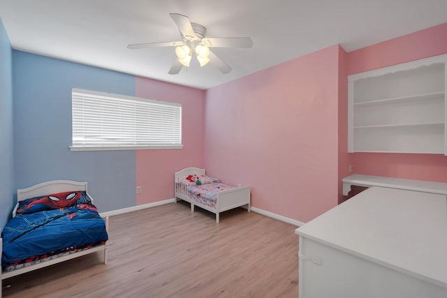 bedroom with light wood-style flooring, baseboards, and ceiling fan